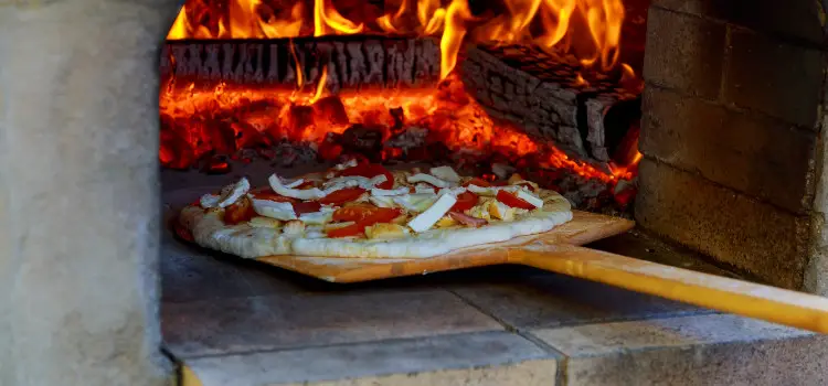 launching pizza in wood oven